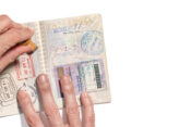 Stamping visa on passport pages with a lot of visa stamps.