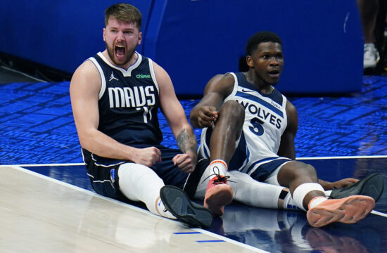 Dallas Mavericks guard Luka Doncic, left, celebrates a charging call against Minnesota Timberwolves guard Anthony Edwards (5) during the first half in Game 3 of the NBA basketball Western Conference finals, Sunday, May 26, 2024, in Dallas. (AP Photo/Gareth Patterson)