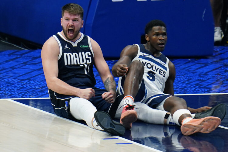 Dallas Mavericks guard Luka Doncic, left, celebrates a charging call against Minnesota Timberwolves guard Anthony Edwards (5) during the first half in Game 3 of the NBA basketball Western Conference finals, Sunday, May 26, 2024, in Dallas. (AP Photo/Gareth Patterson)